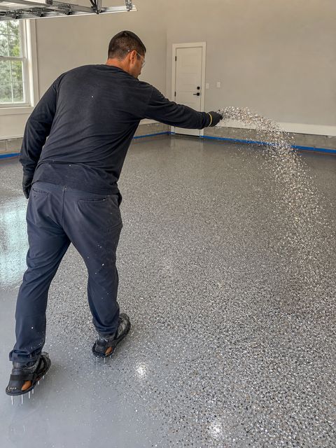 Contractor broadcasting decorative flakes over wet epoxy