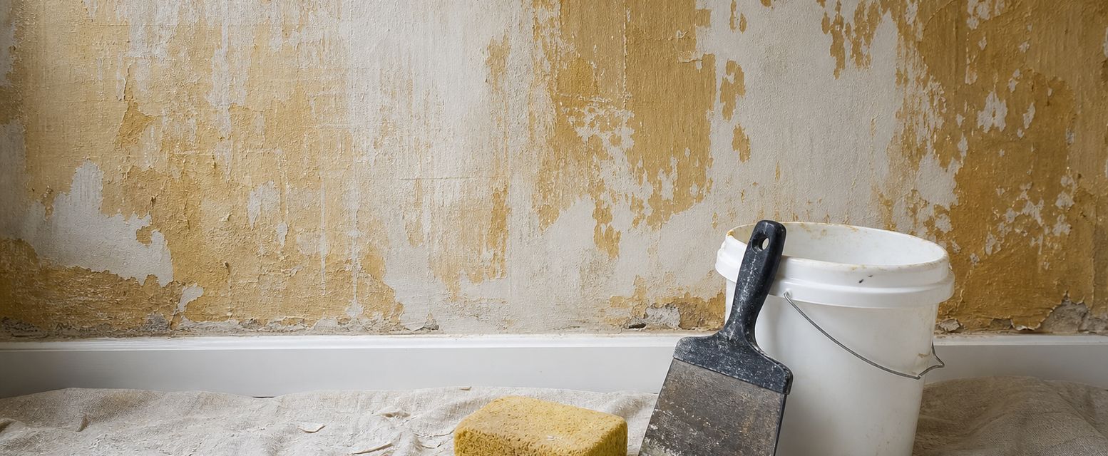 Hand wiping wallpaper glue from a wall